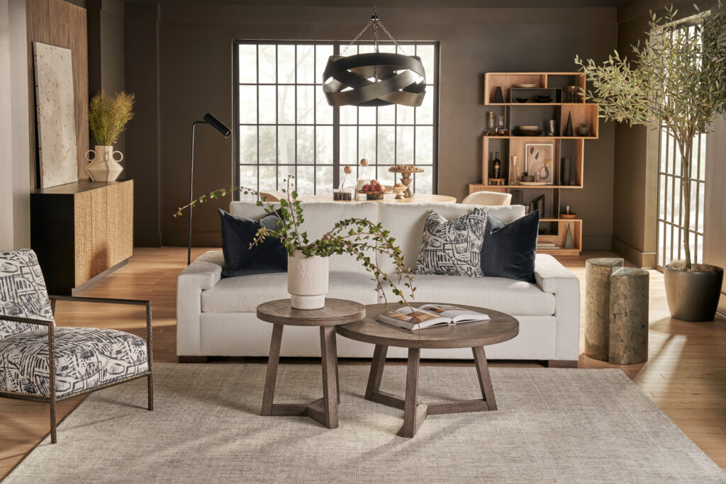 White Modern U Choose sofa with track arms in a living room with black grid windows and a wood shelving wall.
